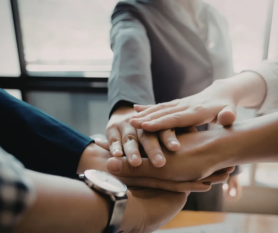 Begleitung und Optimierung – Hände im Team als Symbol für partnerschaftliche Zusammenarbeit